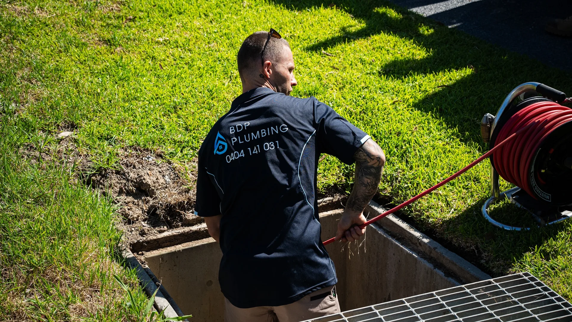 Plumber clearing a stormwater pit with a jetter hose